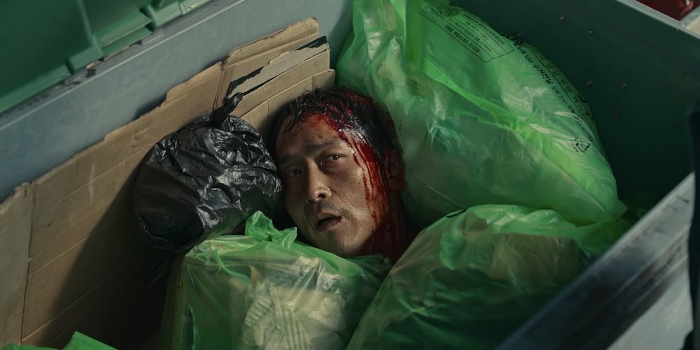 Episode 2 Scene - Lee Tang opens a garbage bin and finds a man with a bleeding head looking at him